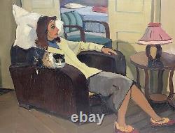 Une femme assise sur son fauteuil avec son chat années 50